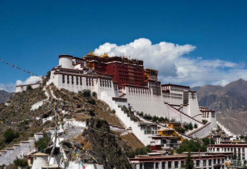 高原林海由翠绿转金黄的山谷与藏式村舍意象