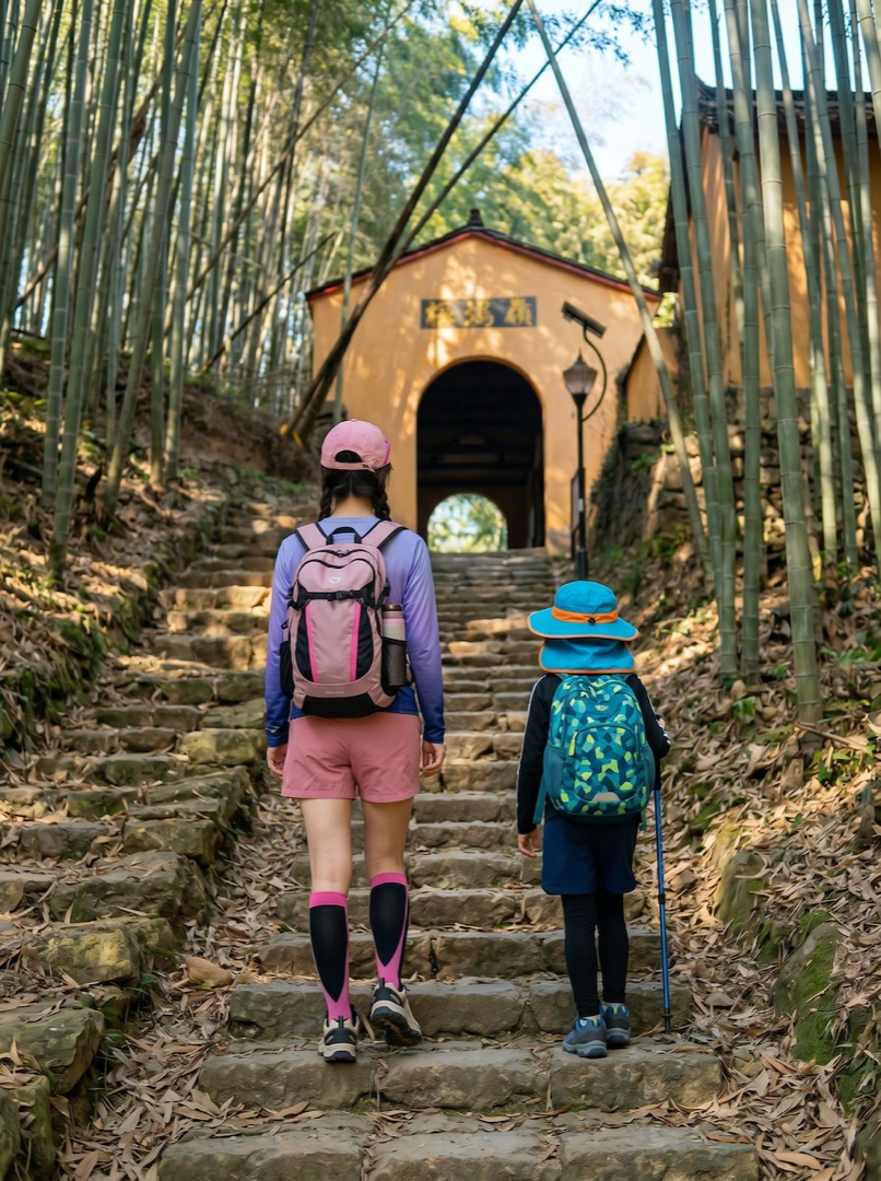 余姚梅坞岭古道竹林石阶，家长与孩子背包向驿廊行进