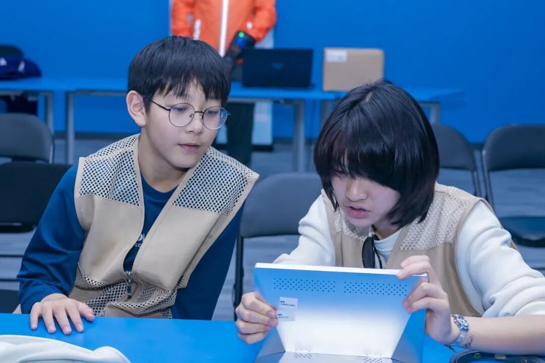 杭州AI科创独立营AIGC动画课，两个孩子用平板协作创作