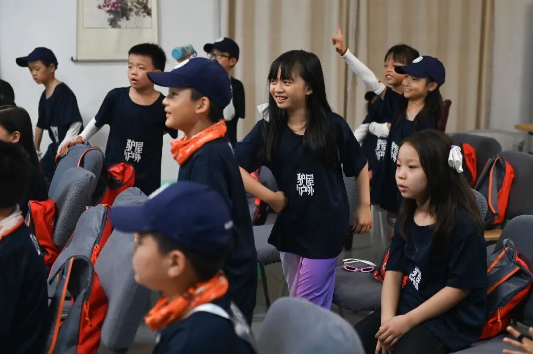 驴屋独立营入营破冰现场，孩子们穿营服举手互动