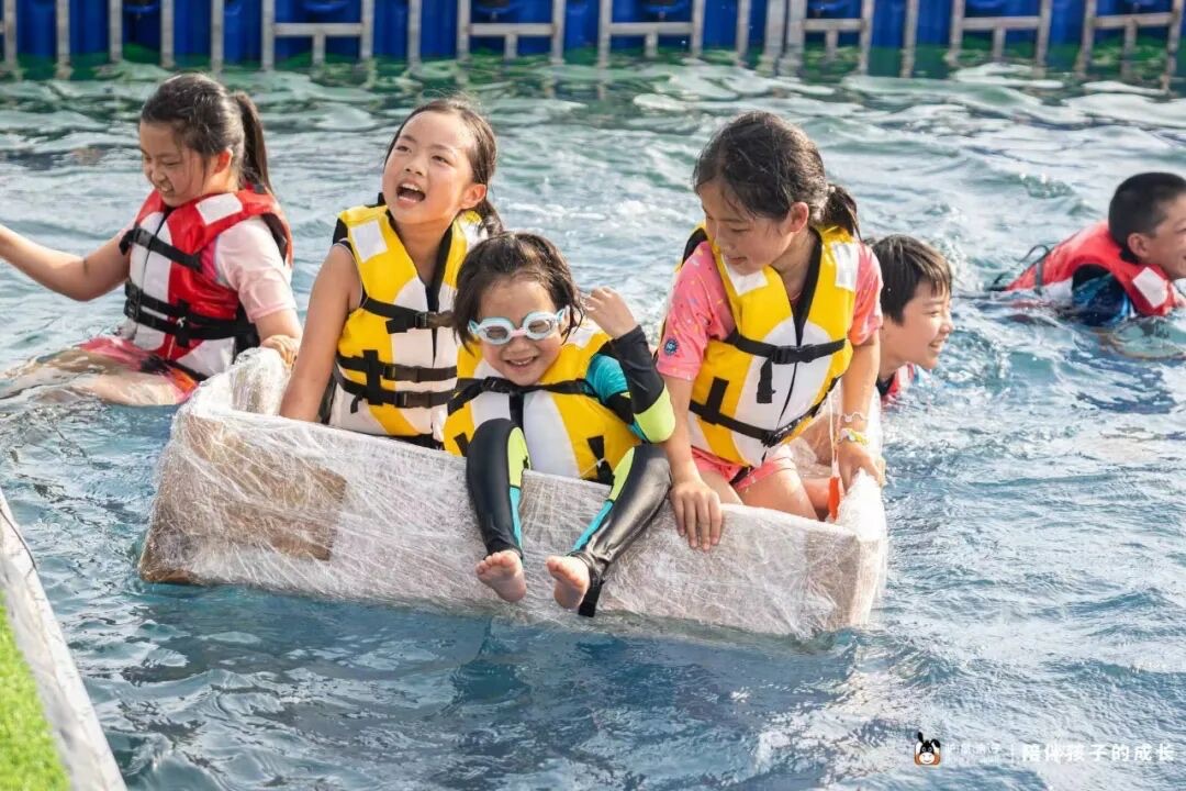 独立营孩子穿救生衣在水池完成纸箱船挑战