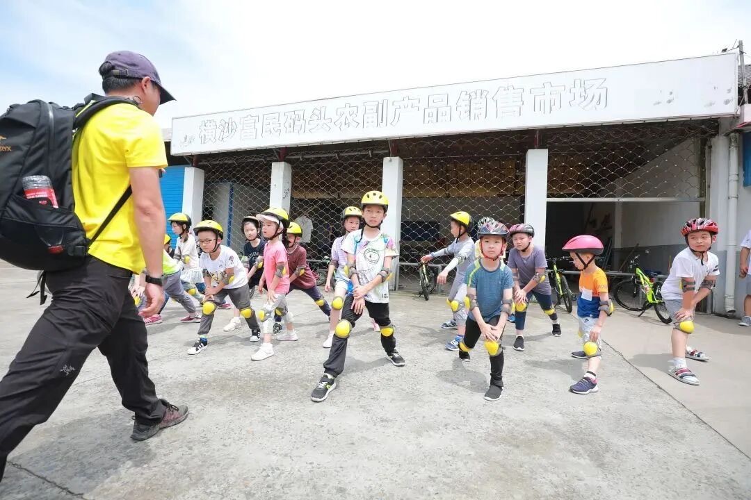 孩子们佩戴头盔护具在横沙岛海堤骑行道上列队骑行