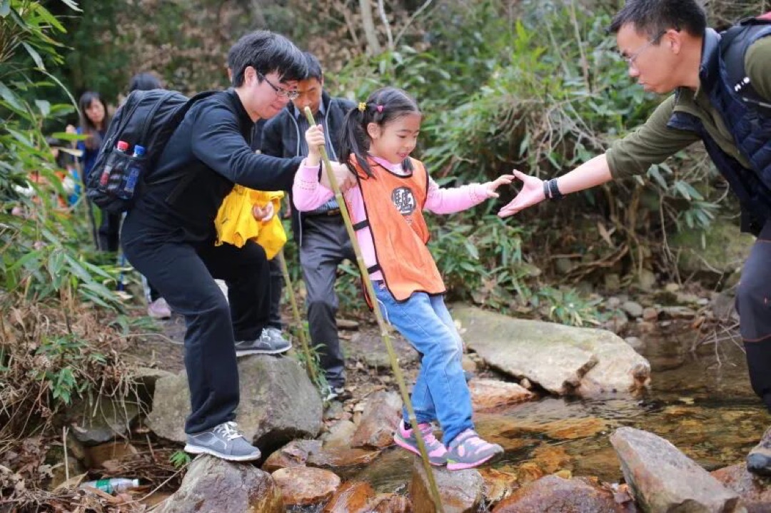 亲子家庭在上海周边的山野步道上结伴徒步，穿越树林小径