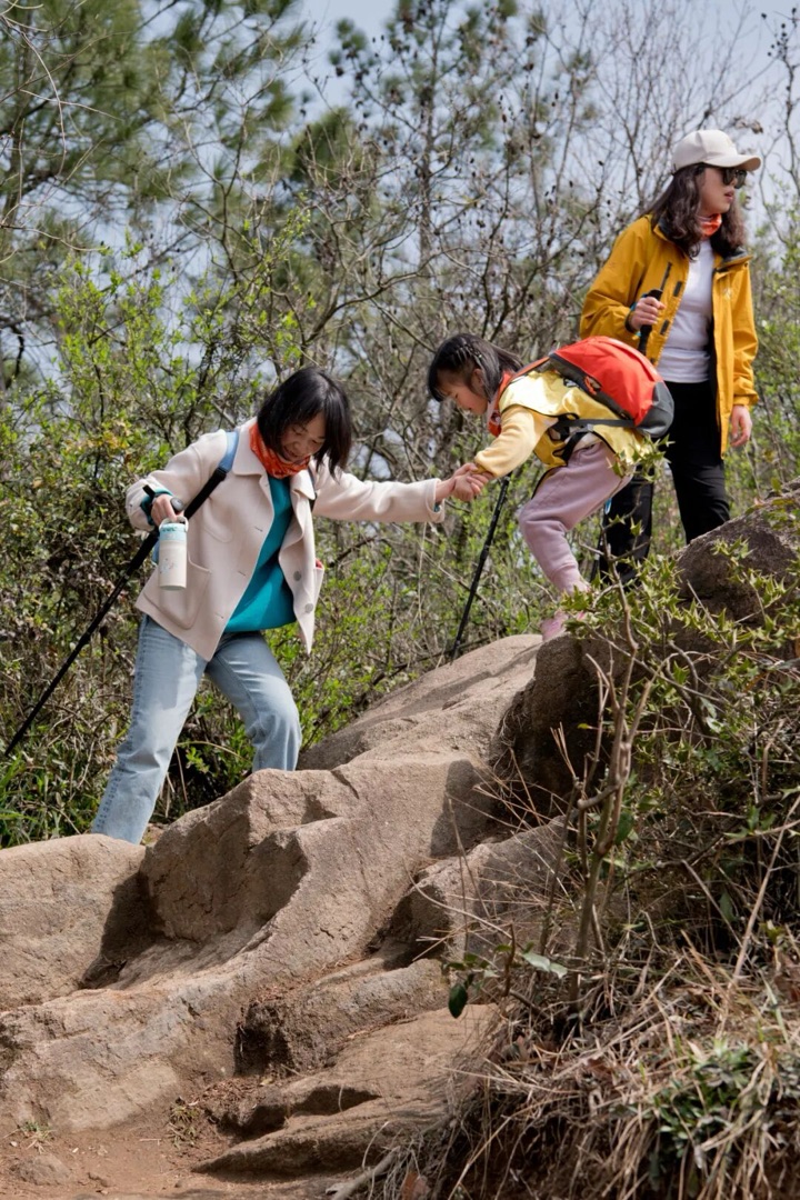 苏州灵白线岩石陡坡路段，教练协助孩子攀爬